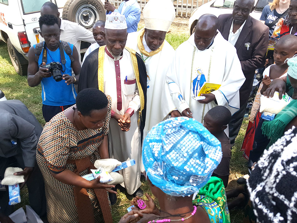 Hon Pauline Kemirembe offering out items to the sick