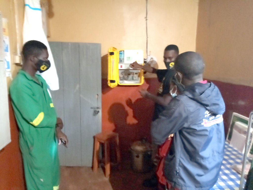 The in-charge of Kyango Healht Center Mr. Muwonge Innocent being taught how the system operates by the We Care Solar system engineers